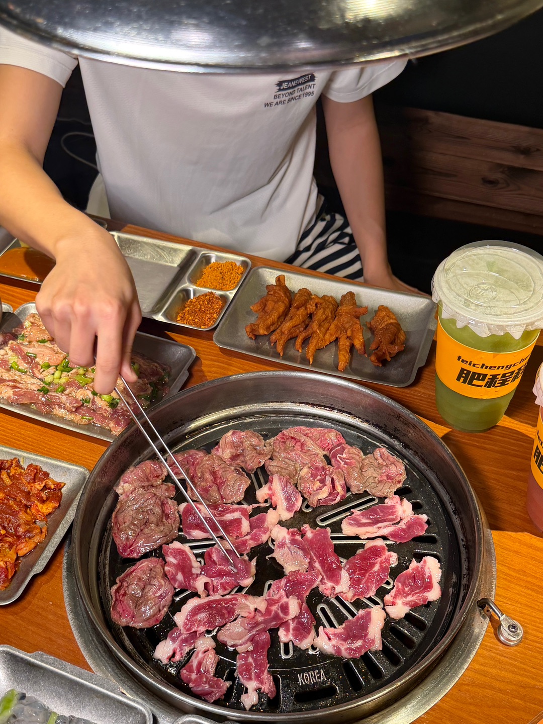 外地游客来湛江金沙湾海边 给我🐛这家烤肉店 肥程程首家配备室内空调的门店 终于开在金沙湾保利酒吧街啦 菜品品质和万达总店完全同步 招牌口味一点不差 舒舒服服吹着冷气吃炭火烤肉‼️ - ✔️原切雪花牛肉&三花趾 纹理超漂亮的鲜切牛肉 炭火烤完鲜嫩多汁 自带肉香 裹上独家蘸料好好吃 ✔️虎皮凤爪 先卤后烤超软糯 轻轻一抿就脱骨 ✔️配菜搭配西葫芦、口蘑和馒头片 素菜吸满肉汁格外好吃😋 ✔️肥程程柠檬茶...