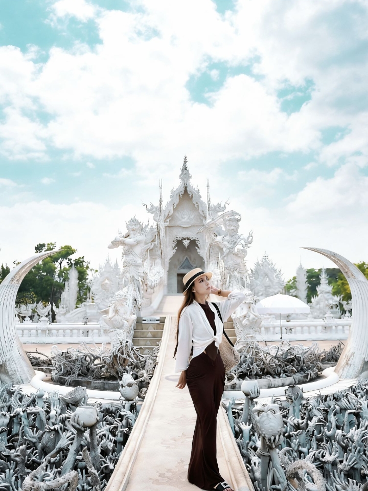 泰国🇹🇭清莱旅行的神仙机位，过于震撼｜ 虽然从清迈坐车3个多小时才能到，但亲眼见到的那一刻，真的会觉得一切都值了。它根本不像传统寺庙，更像一座坠入凡间的纯白艺术品！阳光下整座建筑闪闪发光，白色基底镶嵌着无数细小的镜面玻璃，反射出夺目光芒。 · 走过那座布满“地狱之手”的桥时，千万不要回头，寓意是从世俗欲望走向心灵净土的升华，设计太绝了！作为拍照圣地，随手一拍都是明信片级别的纯净圣洁。建议趁现在还不...