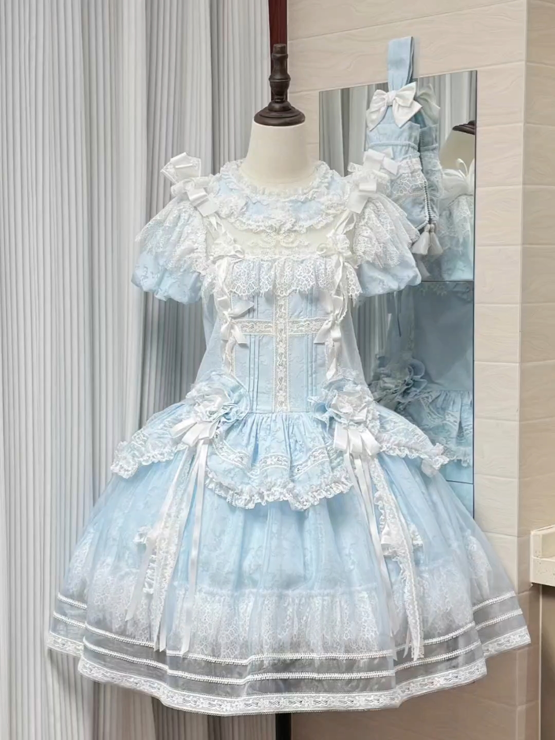 这个水色真的好心动啊！特别清透似水，像把初夏清晨的薄雾裁进了裙身 奶油般的绶带和蝴蝶结错落点缀，软乎乎的质感衬得蕾丝花边愈发精致，每一处褶皱都漾着温柔的光泽，仿佛下一秒就要化作云朵飘起来